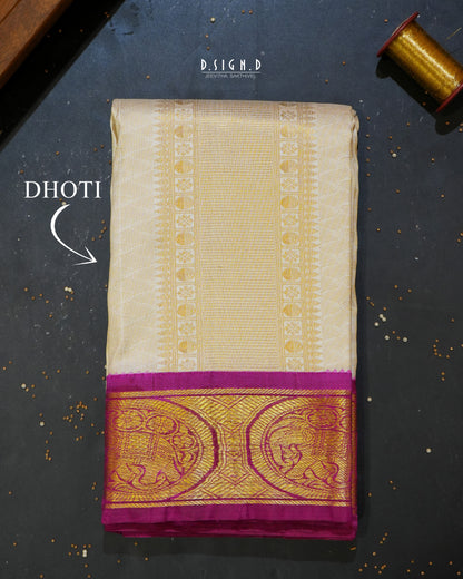 A folded cream-colored silk dhoti with a wide gold zari border and a magenta-pink pallu, displayed on a dark textured surface with 'DHOTI' text overlay.