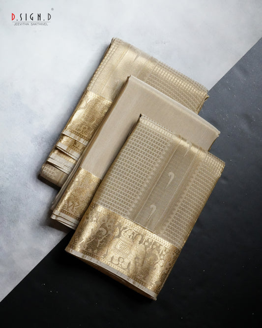 Three folded dark gold patterned fabric pieces, likely dhoti or textiles, arranged diagonally on a split light gray and black background. The fabric features intricate woven patterns and a metallic gold border.