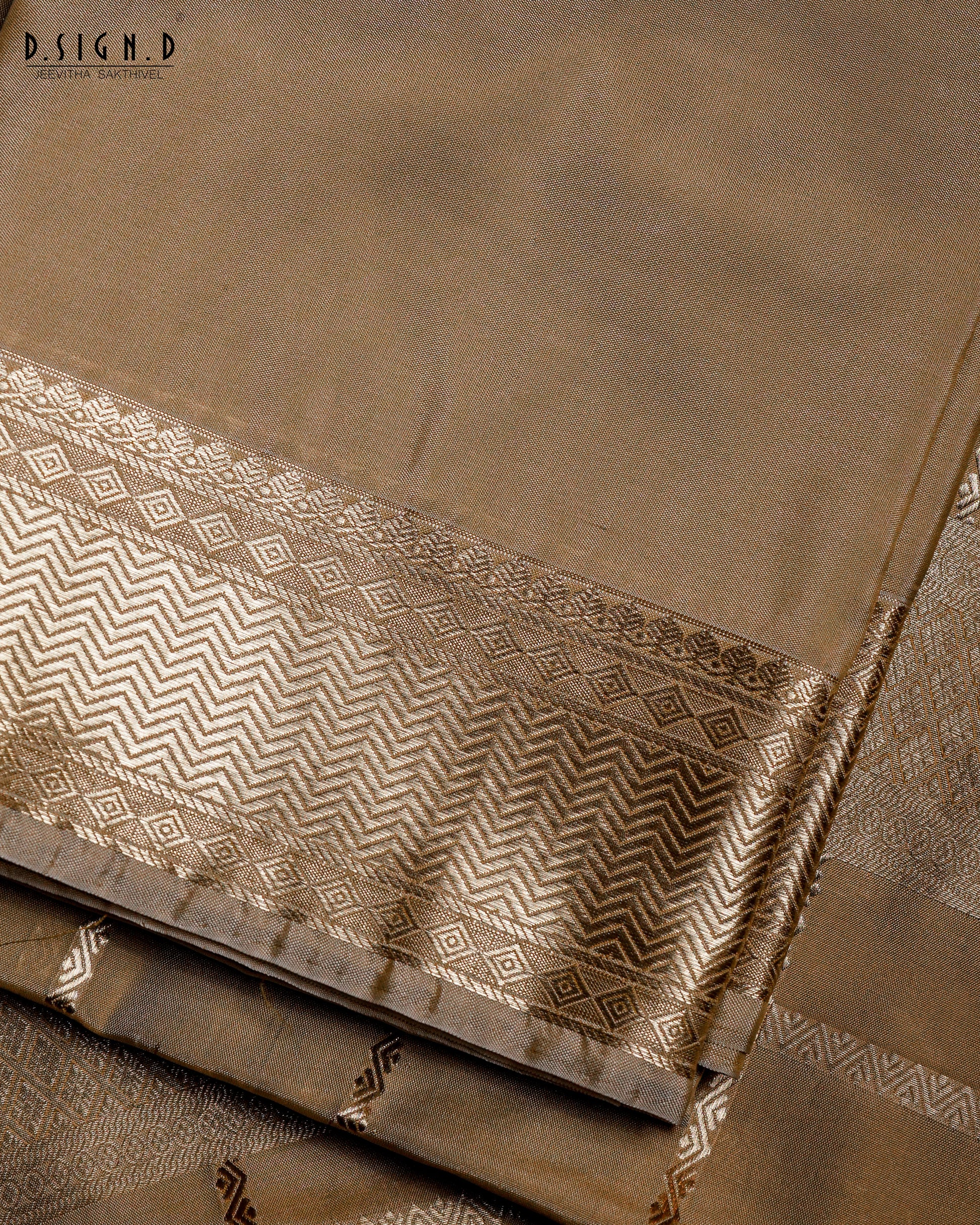 Close-up of dark gold silk dhoti set showing traditional Kattam checks and textured geometric zari border