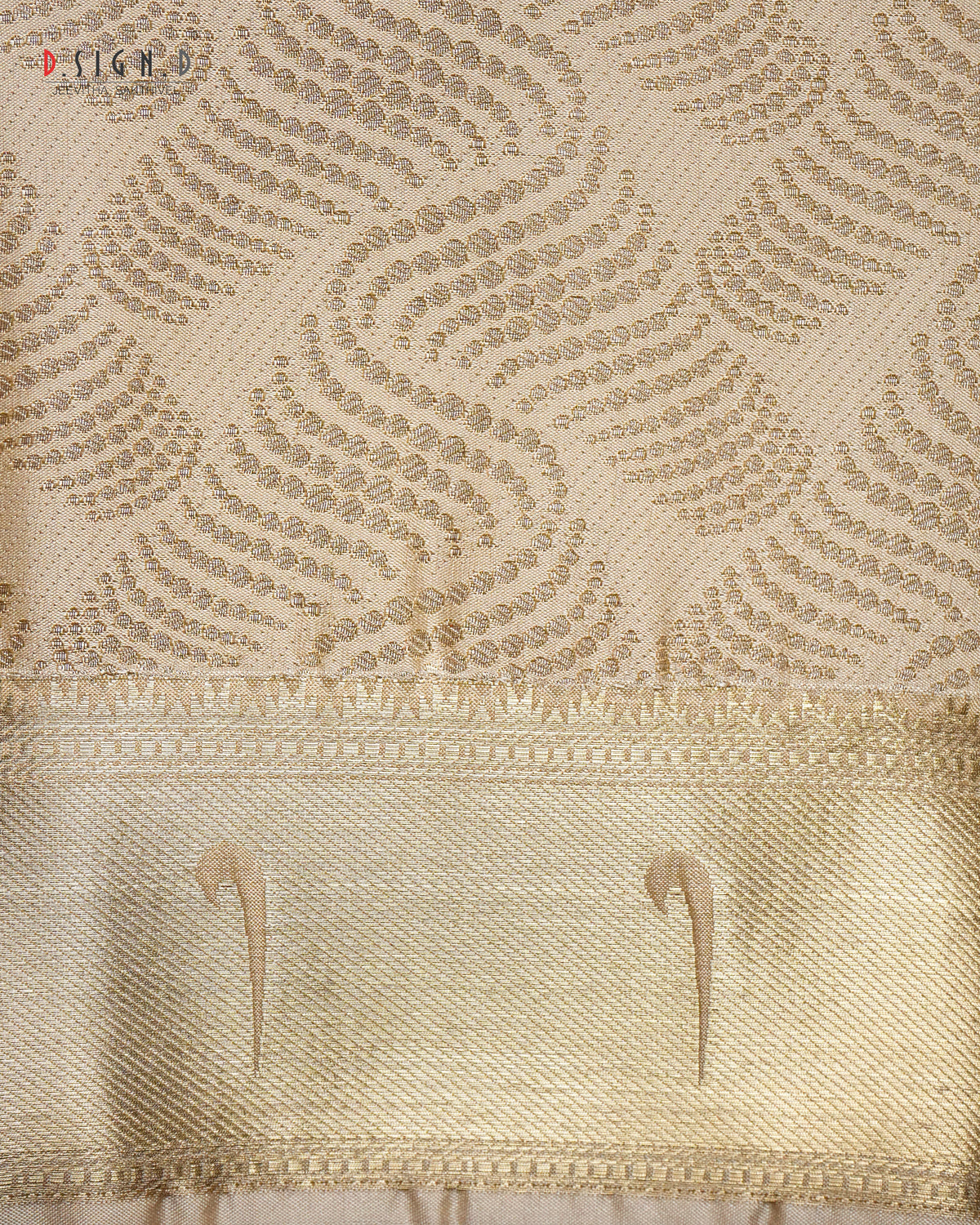 Close-up of a gold silk fabric with a woven floral pattern and a wide decorative border.