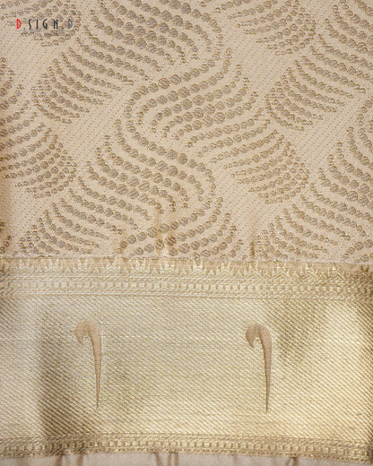 Close-up of a gold silk fabric with a woven floral pattern and a wide decorative border.