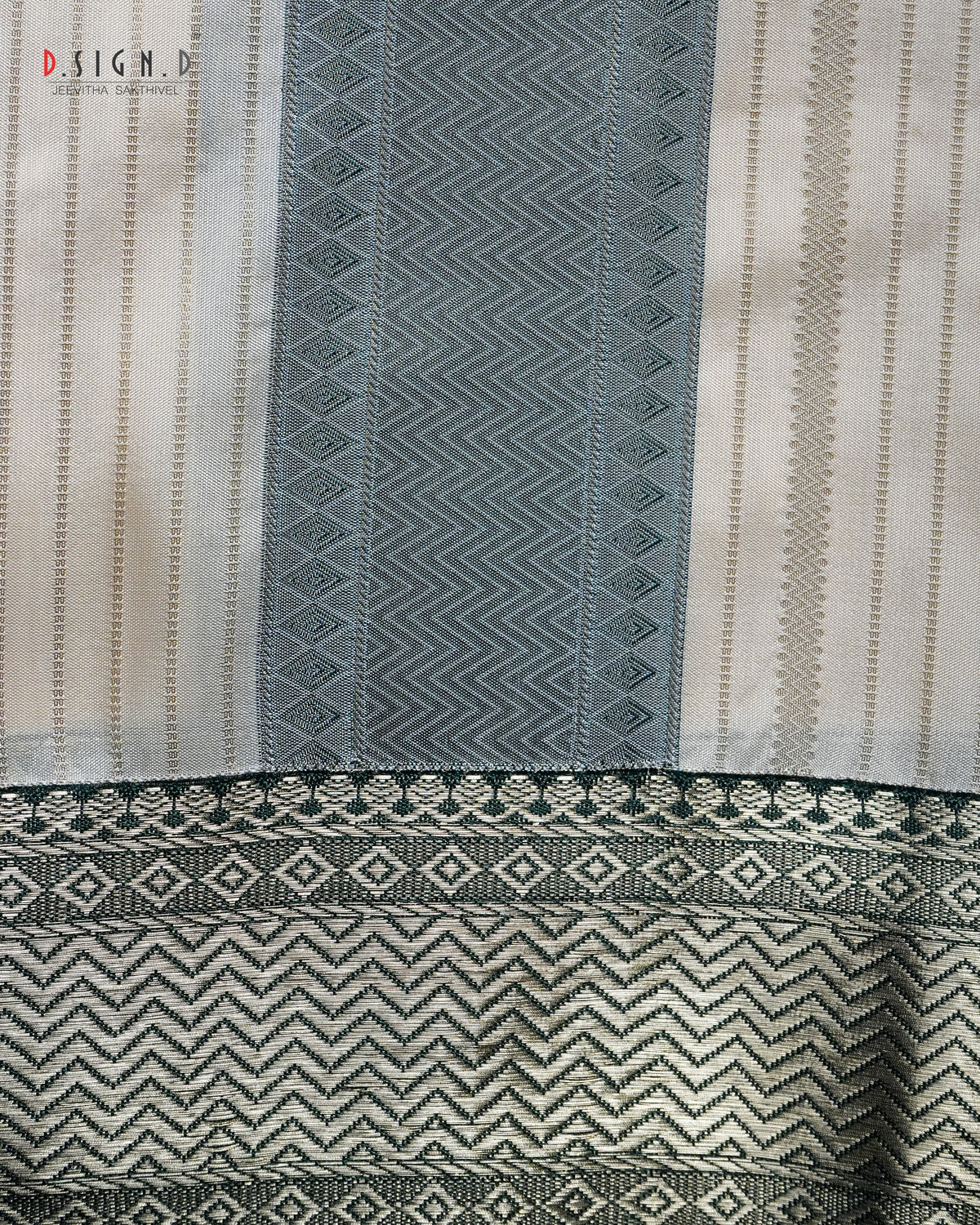 A close-up of a woven textile with vertical panels in cream, green, featuring geometric and chevron patterns with a decorative border.