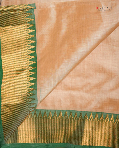 A peach-colored silk dhoti with a wide gold and green zari border, shown folded to display both the body fabric and the detailed metallic trim.