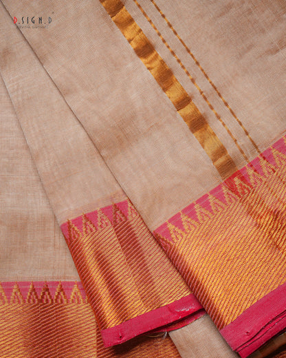 A close-up of a copper silk dhoti with a vibrant red zari border, showing the texture and weave details.