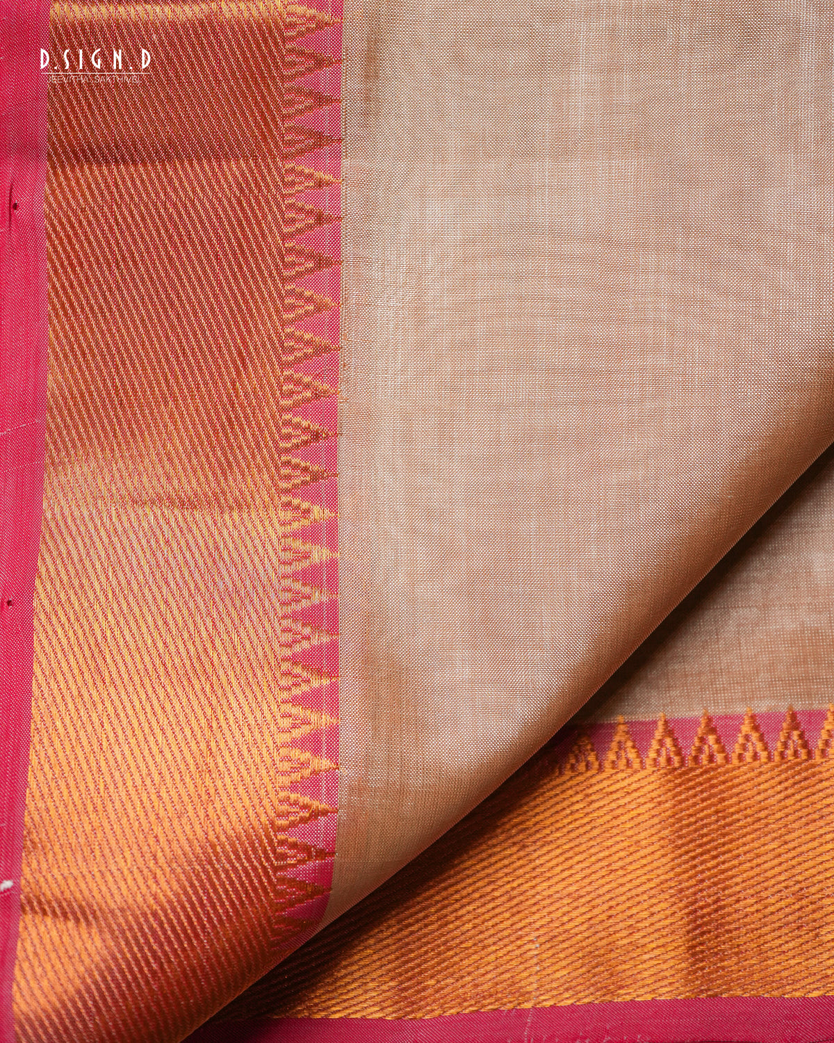 A close-up of a copper silk dhoti & vastram with a vibrant red border, folded to show both the plain body and the decorative zari work.