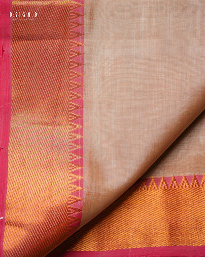 A close-up of a copper silk dhoti & vastram with a vibrant red border, folded to show both the plain body and the decorative zari work.