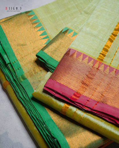 A folded and draped silk dhoti with a light green body, a vibrant green border, and a golden-yellow zari-embellished pallu section with pink and orange accents. 