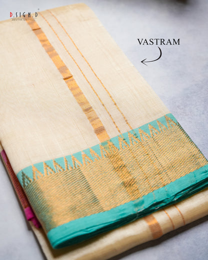 A folded cream-colored silk vastram with gold zari stripes and a teal border.