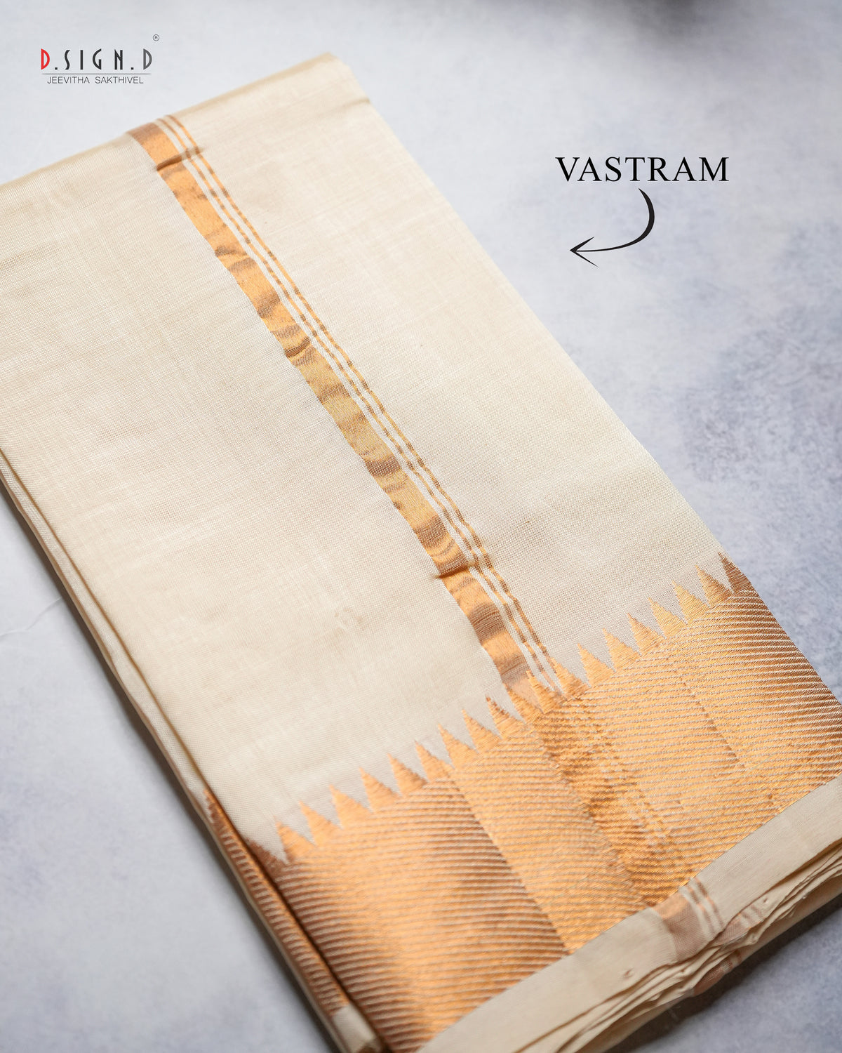 A folded cream-colored silk vastram with a gold zari pattern.