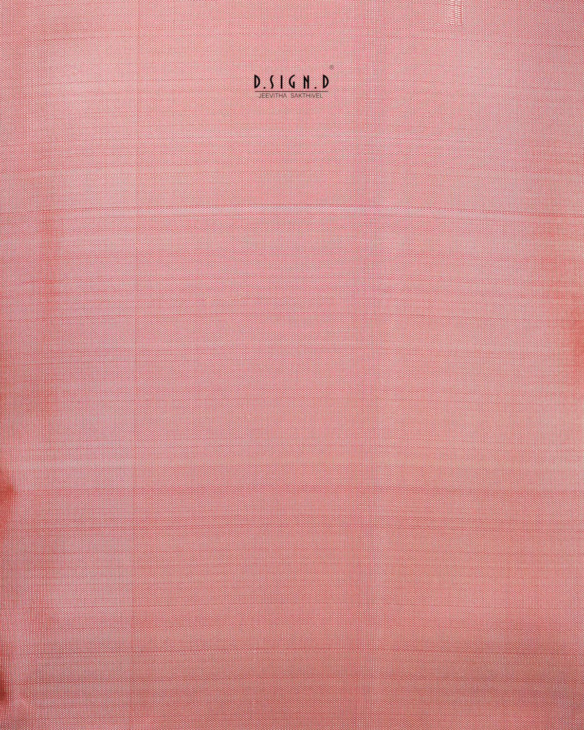 A close-up of a peach woven fabric with a subtle grid texture . 