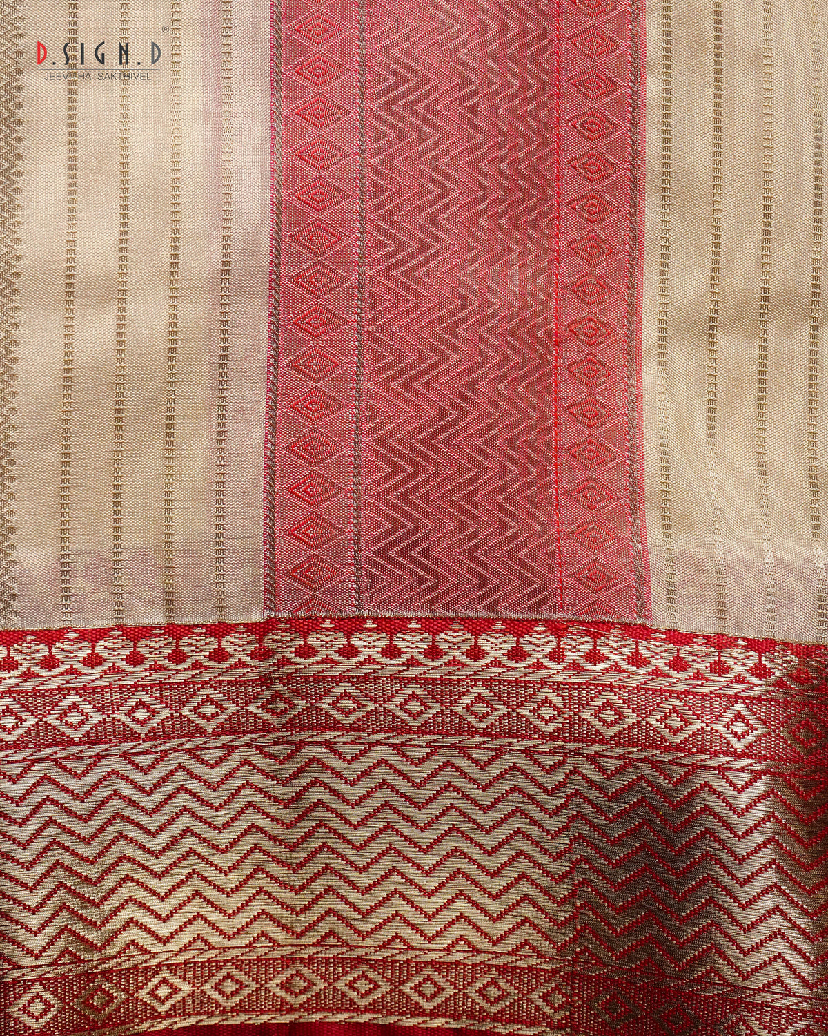 A close-up of a woven textile with vertical stripes and geometric patterns in beige, red, and pink, featuring a decorative border at the bottom. 