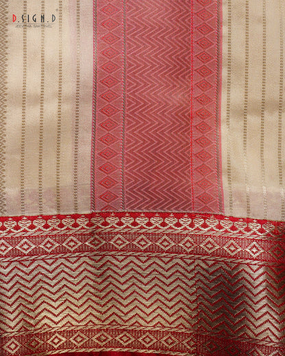 A close-up of a woven textile with vertical stripes and geometric patterns in beige, red, and pink, featuring a decorative border at the bottom. 