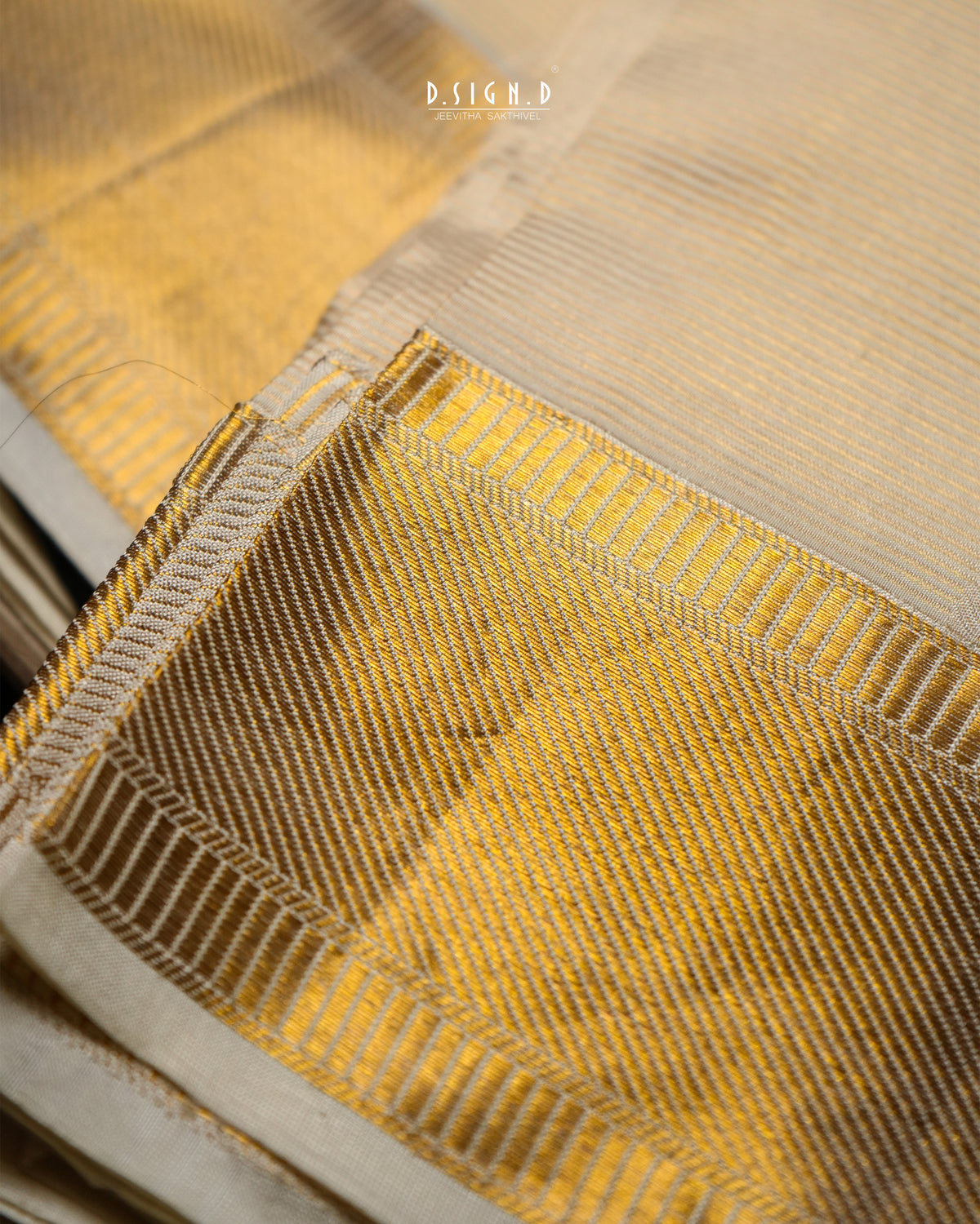 A close-up of a gold and beige woven fabric with a textured pattern and a stitched border, showing the material detail.